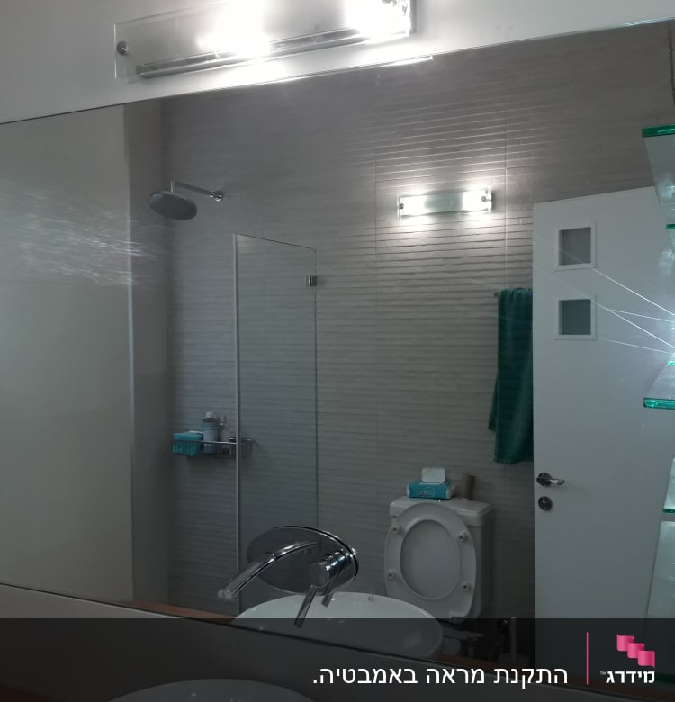 מדף זכוכית בחדר אמבטיה עם מראה גדולה